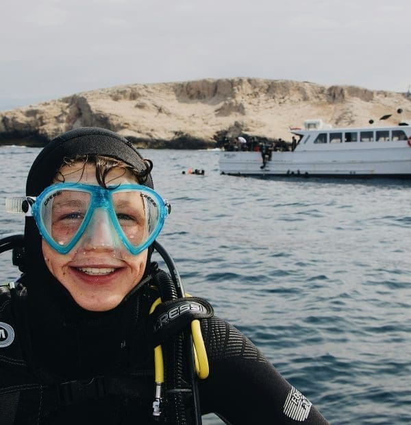 Beginner scuba diver learning underwater skills in a training pool.