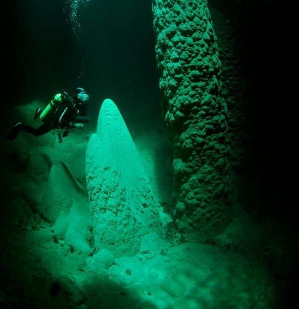 Diver exploring underwater cave formations.