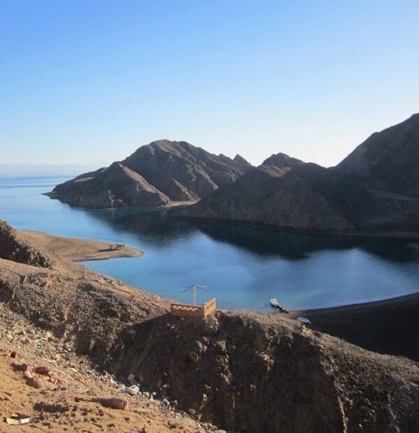 Serene mountainous coastline with calm blue water.