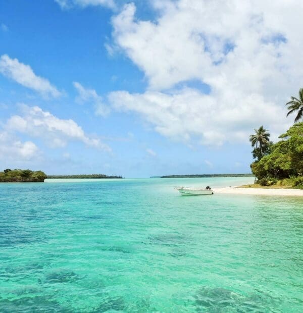 Tropical beach with clear turquoise water and boat.