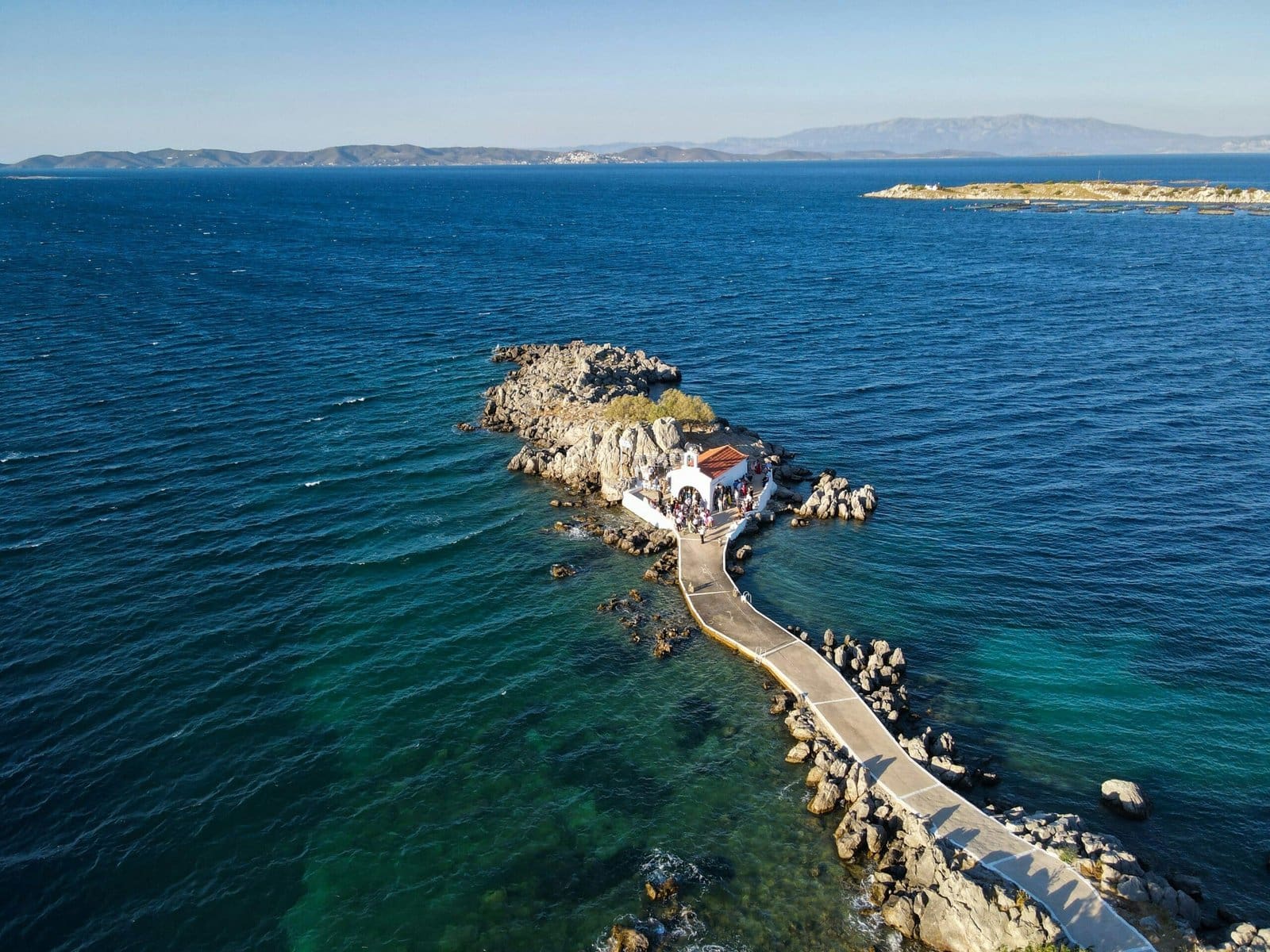 Aerial view of rocky coastline with small white building