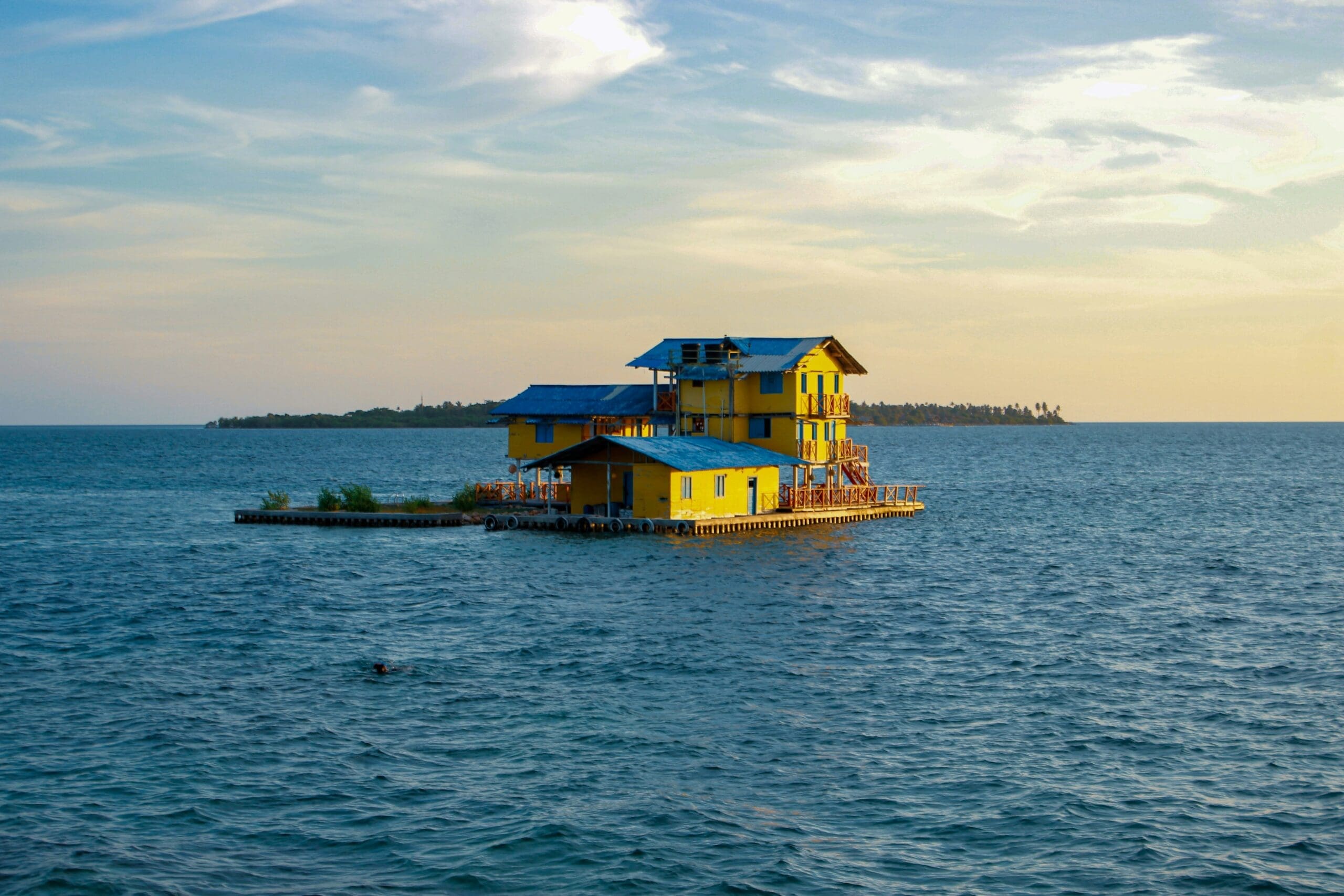 Yellow floating house on serene blue ocean