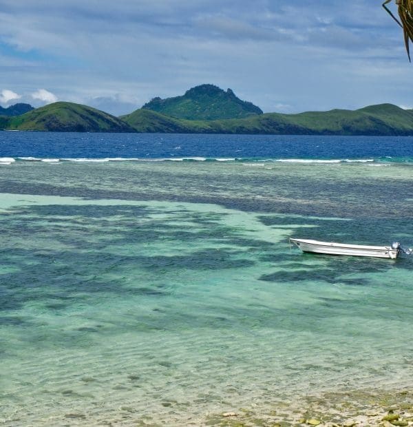 Tropical lagoon with boat and distant island hills.