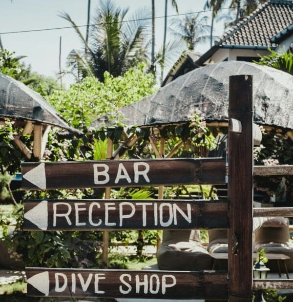 Wooden signpost with directions to bar, reception, dive shop.