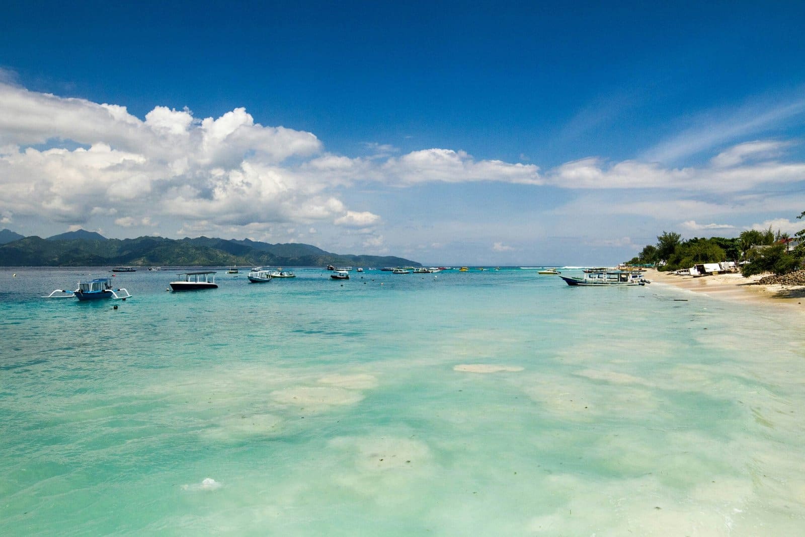 Tropical beach with boats and clear turquoise water