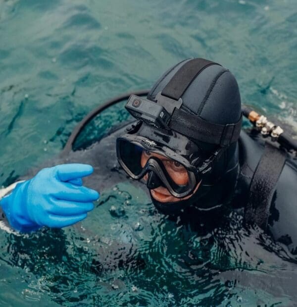 Scuba diver with camera on helmet in ocean.