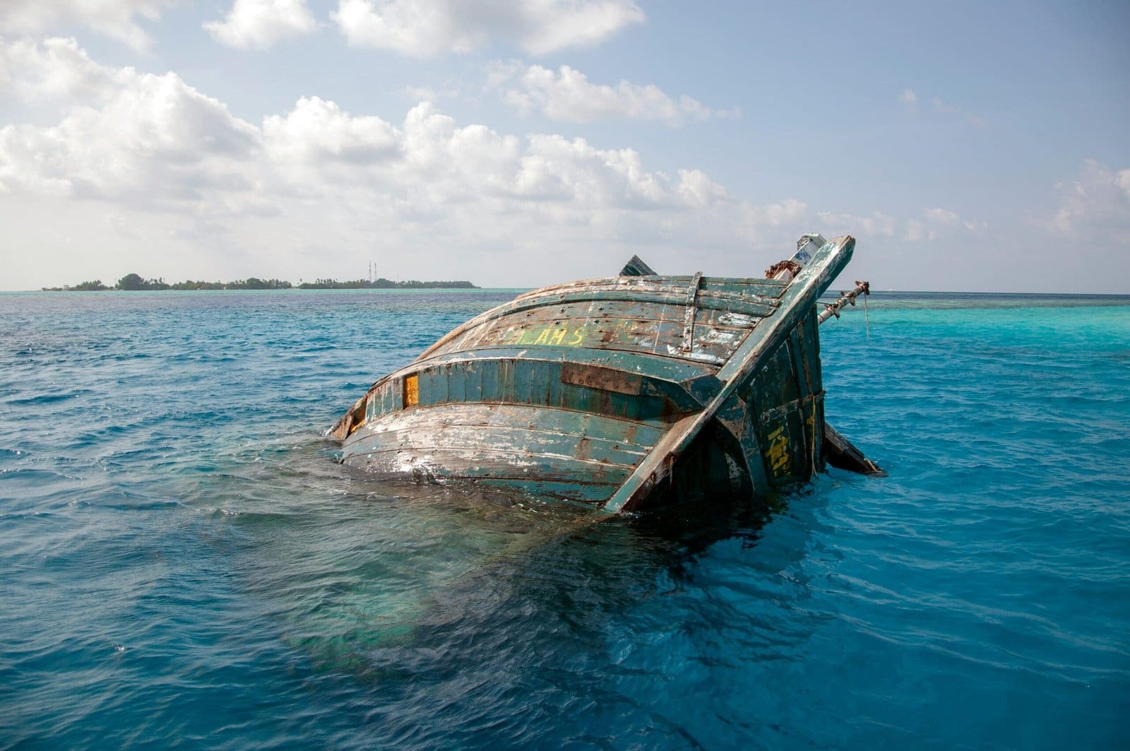 Sunken boat in clear turquoise ocean water