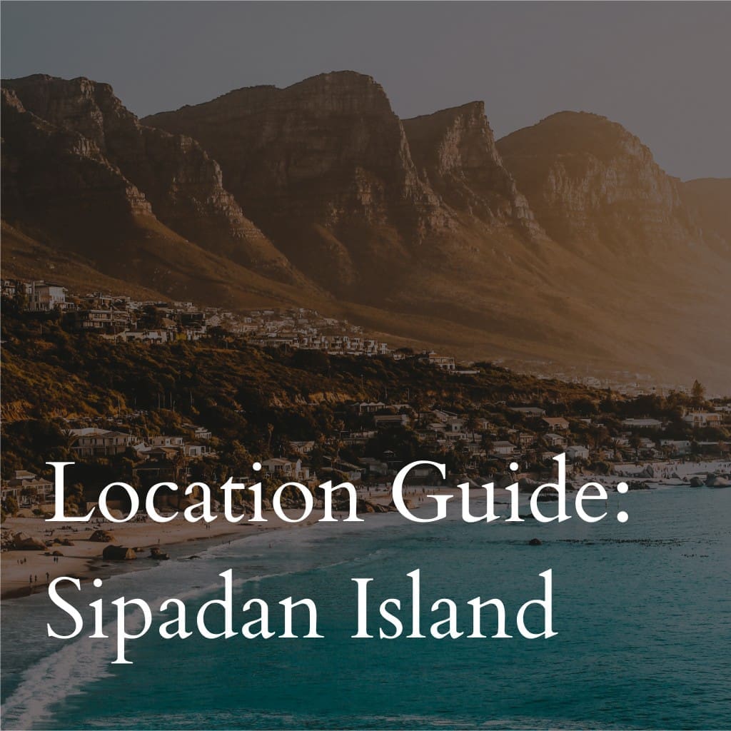 Sipadan Island guide text over coastal mountainous landscape