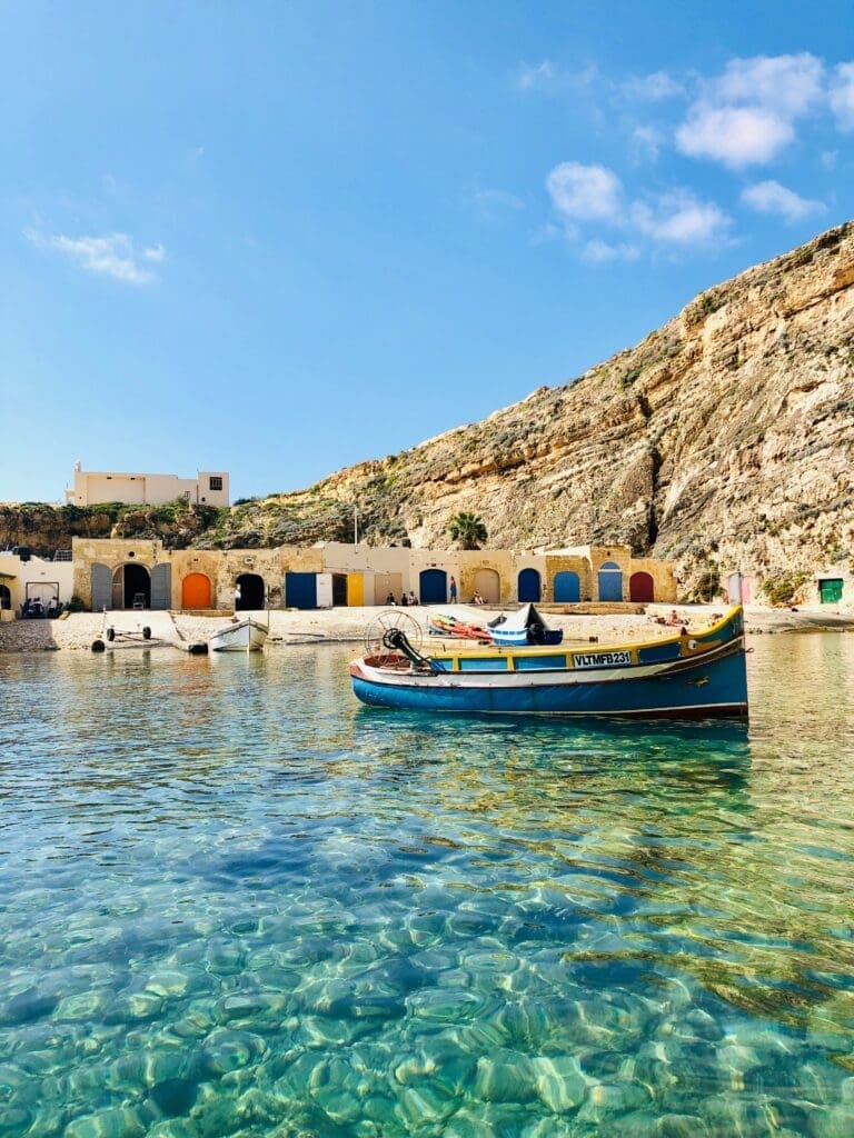 Colorful boats by rocky cove with clear blue water