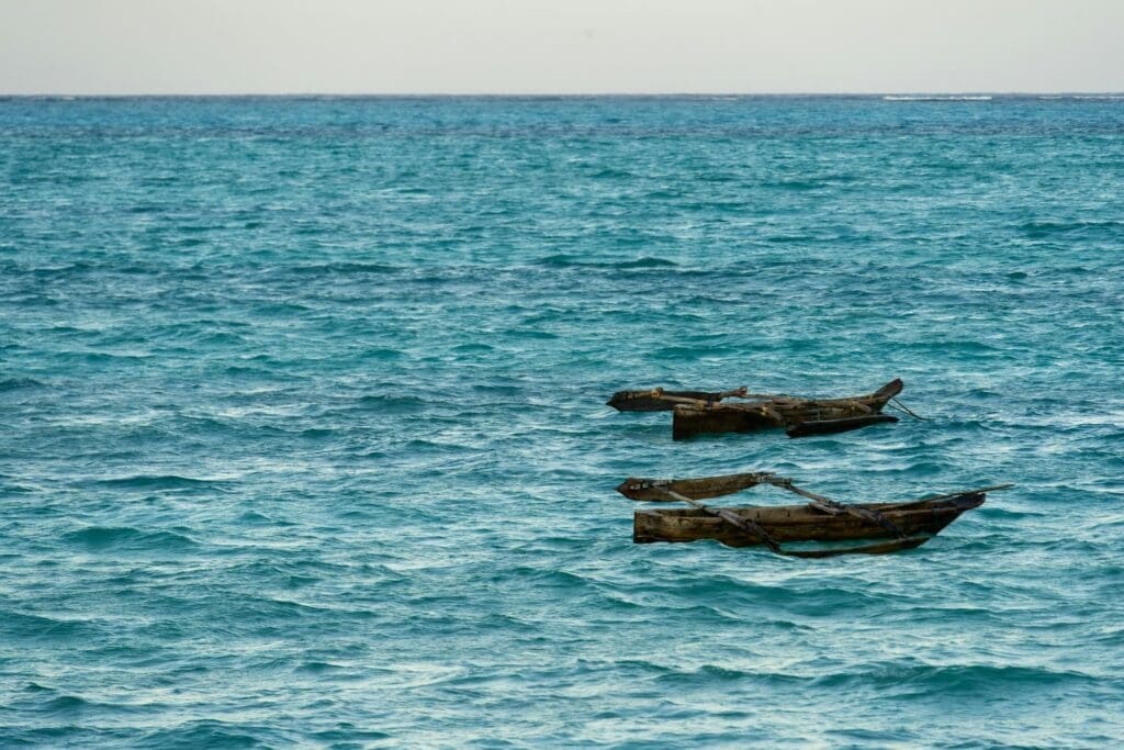 Two wooden boats floating on vibrant blue ocean