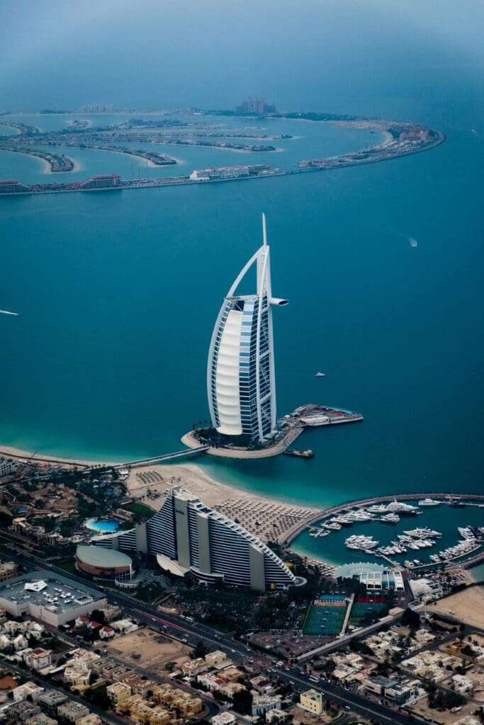 Aerial view of sail-shaped skyscraper by coastline