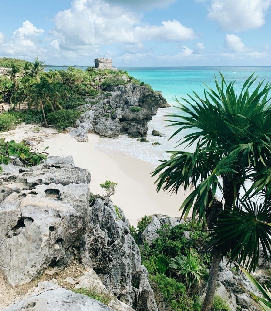 Tropical beach with lush foliage and ancient ruins