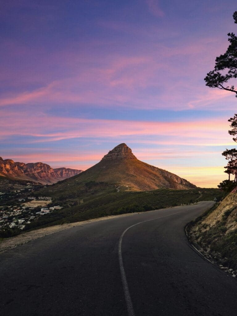 Sunset over mountain road with pink and blue sky